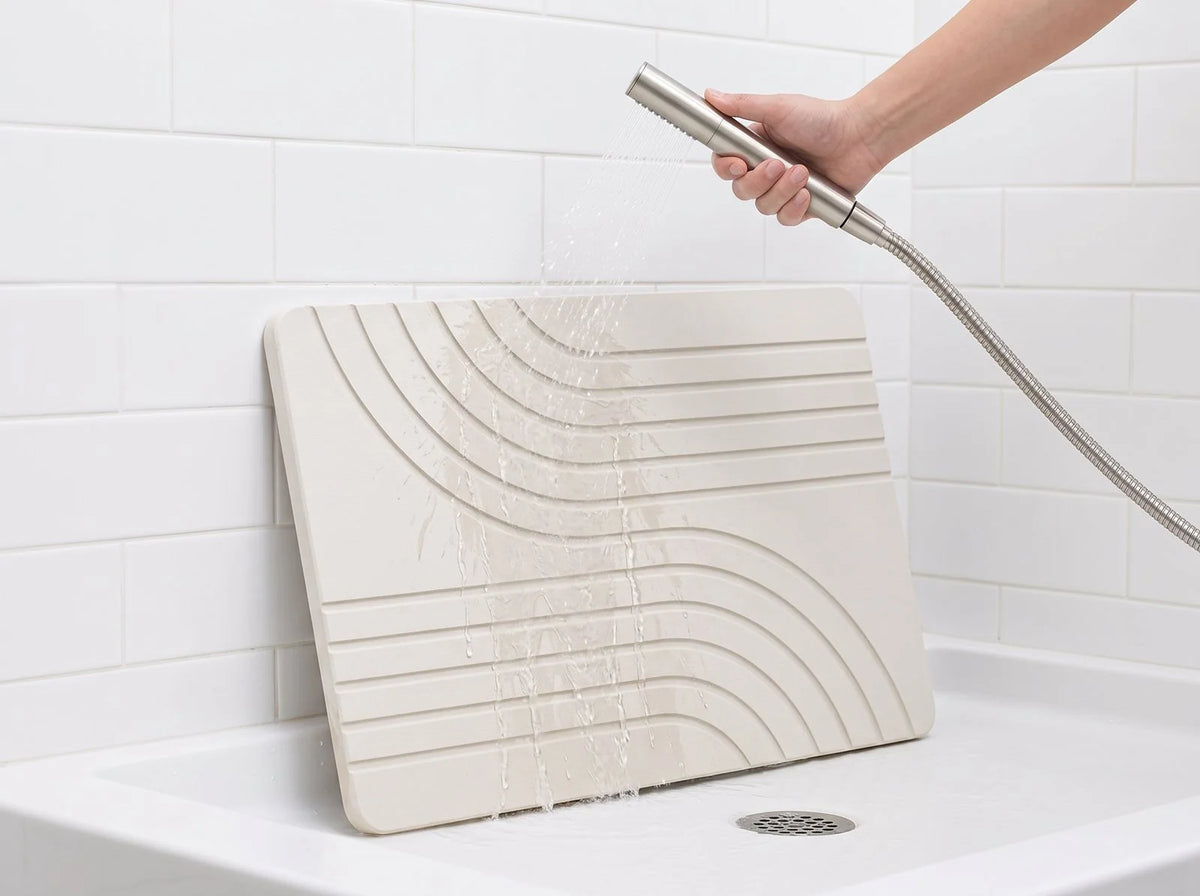 Rinsing the Vitaxe stone bath mat with a handheld shower sprayer